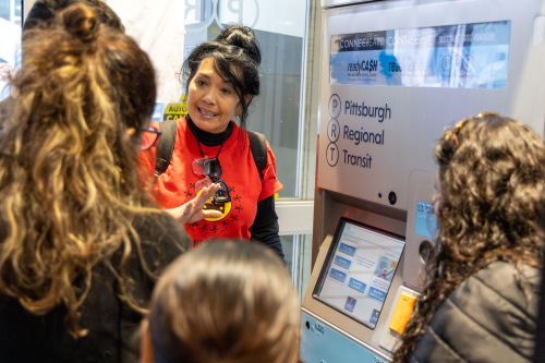 A tour guide from Pittsburghers for Public Transit shows visitors to the Downtown Service Center how to use a ConnectCard machine